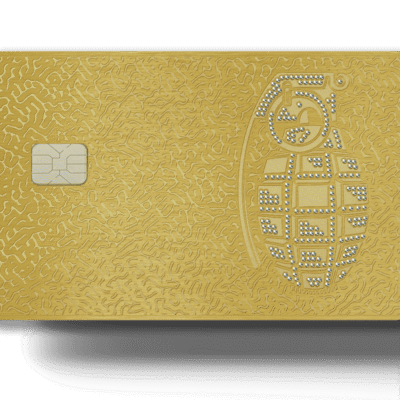 Gold Lion Card with embedded microchip and detailed engraving of a grenade design decorated with rhinestones, representing innovative payment solutions and unique branding.